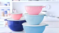 three bowls stacked on top of each other in different colors and sizes, with the lids down