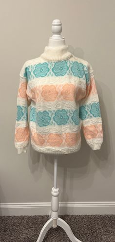 This sweater is adorable!  It's so 80s!  I loved acrylic sweaters like this back in the 80s.  They had a novelty cuteness to them.  Some had hearts, this one has flowers.  It has never been worn.  The base is a creamy white, with pastel aqua/seafoam green (leans a bit dark in the photos due to lighting) and pastel peach.  The peach looks a bit like orange sherbet.  Soft and oh so cozy, this one is great for those cool fall/winter nights!  It is a size Medium, with its original tag still stapled to the front.  Please see measurements below.  Super cute, with a slightly fuzzy texture.  I love it!  Thanks for looking! Measurements taken laying flat:  please double for chest & waist Armpit to armpit 19.75" Waist/middle 19" Sleeves from collar 24.5" Length 24" Cabin Sweater, 80s Inspired Outfits, 80s Pastel, 80s Girl, Novelty Sweater, Fuzzy Texture, 80s Floral, Orange Sherbet, 80s Sweater