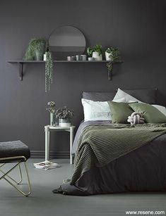 a bed room with a neatly made bed and some plants on the shelf above it