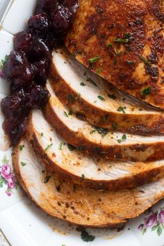 slices of pork with cherries on a plate