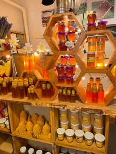 jars of honey sit on shelves in front of flowers and other items that are arranged around them