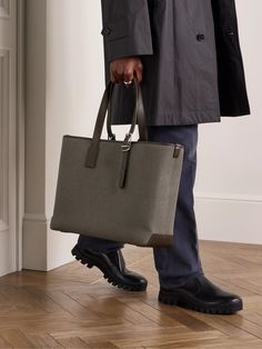 This tote bag is from the Dunhill’s '1893 Harness' collection, the buckled leather detailing pays homage to the brand’s saddlery heritage. Reinforced with leather trims, it's been woven in Italy and sized for your business essentials, like a laptop and notebook. The internal zipped pocket is ideal for tucking your phone and business cards. High-end Coated Canvas Satchel For Business, Designer Shoulder Bag With Leather Trim For Business, Business Shoulder Bag With Gunmetal Hardware And Coated Canvas, High-end Leather Bag With Leather Trim, Business Shoulder Bag With Gunmetal Hardware, Designer Business Bag With Leather Trim, High-end Business Bags With Leather Trim, Designer Office Bags With Leather Trim, Designer Office Bag With Leather Trim