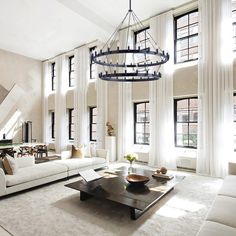 a living room filled with white furniture and lots of windows in the wall next to each other