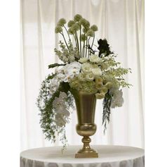 a vase filled with white flowers sitting on top of a table