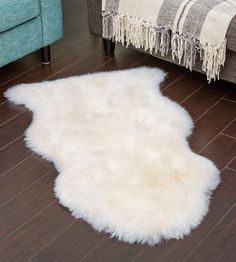 a white sheepskin rug on the floor next to a couch