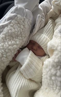 a baby wrapped up in a white blanket