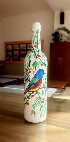 a painted bottle sitting on top of a wooden table