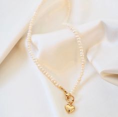 This necklace features a brass puff heart, gold-filled clasp, and freshwater pearls, all of which come together to form a beautiful and unique piece. Length: 16" Pearl Heart Necklace, Pearl Heart, Puffed Heart, Freshwater Pearl Necklace, Freshwater Pearl Necklaces, Heart Jewelry, Heart Necklace, The United States, Unique Pieces