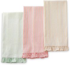 three towels with ruffled edges are lined up on a white surface, one in red and the other in green