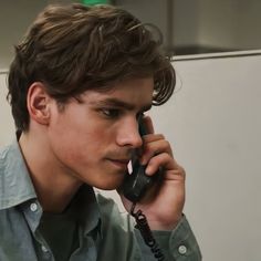 a young man is talking on the phone