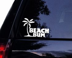 a sticker on the back of a car that says beach bum with a palm tree