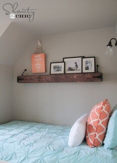 a bed with two pictures on the wall above it and an orange sign that says keep calm