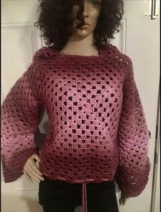 a mannequin wearing a pink crocheted sweater