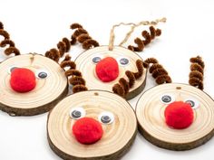 four wooden slices with reindeer faces and noses on them, hanging from twine strings