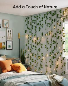 a bedroom decorated with green ivy leaves and string lights on the wall behind the bed