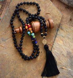 With this Chakra Mala Necklace, I feel protected, guided, and strong One of our favorite Chakra mala beads in the collection. This Mala is made of a combination of black onyx beads and the 7 beads that correspond to the seven chakra system: Rose quartz, green aventurine, lapis lazuli, jasper, carnelian, amethyst, and tiger eye. The Mala ends with a Lotus Flower pendant and a black tassel. Lotus Flower is an ancient symbol pointing to the wisdom and realization that all forms in life are part of Mala Beads Diy, Yoga Necklace, Mala Bead Necklace, Beads Mala, Chakra System, 108 Mala Beads, Chakra Necklace, Les Chakras, Onyx Necklace