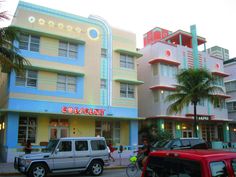 cars parked in front of colorful buildings and palm trees