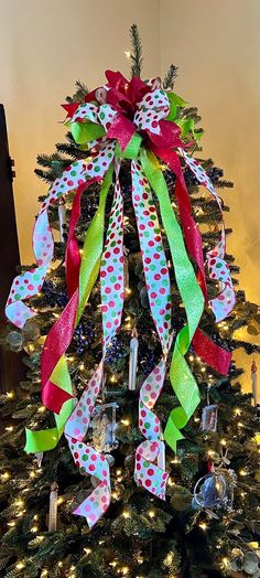 a christmas tree decorated with ribbons and bows