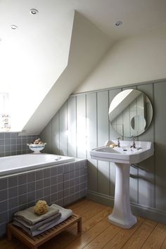 a white sink sitting under a bathroom mirror next to a bath tub in a room