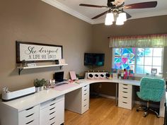 a room with a desk, chair, and window in the corner that has a sign on it