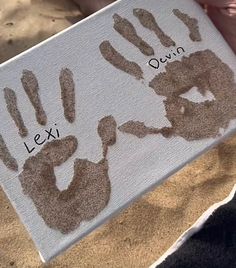 someone holding up a sign with their handprints on it that says lexi and ouvin