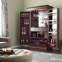 a living room filled with furniture and lots of bottles on top of the shelves next to a window