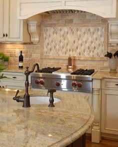 a kitchen with marble counter tops and white cabinets