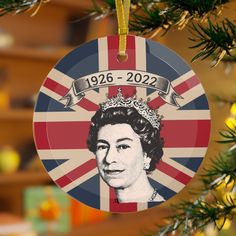 a christmas ornament hanging from a tree with the british flag and queen elizabeth on it