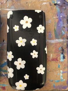 a black case with white flowers painted on it