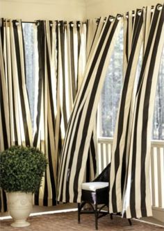 black and white striped curtains in front of a window with potted plant next to it