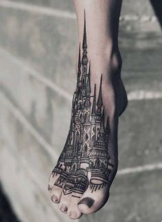 a foot with a castle tattoo on it