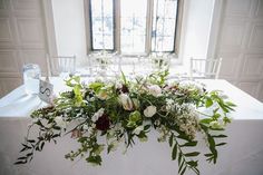 the table is set with flowers and greenery