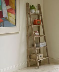 a wooden ladder leaning against a wall next to a shelf with books and magazines on it