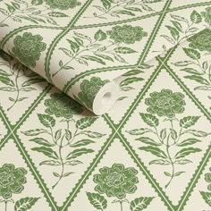 a green and white wallpaper with flowers on it