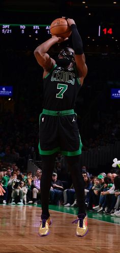 the basketball player is getting ready to dunk the ball in front of an audience