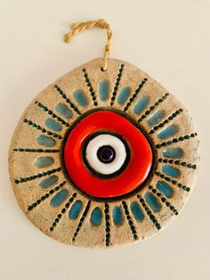 a ceramic ornament with an evil eye in the center on a white background