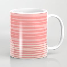 a pink and white striped coffee mug sitting on top of a table