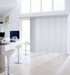 a modern kitchen with white counter tops and bar stools