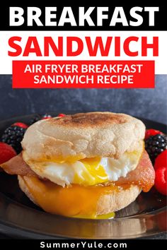 a breakfast sandwich on a plate with berries and strawberries in the background text reads, breakfast sandwich air fryer breakfast sandwich sandwich