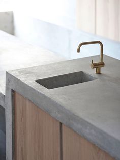 a concrete counter top with a sink and faucet in the middle is shown