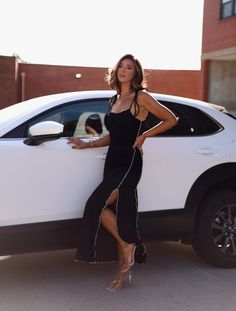 a woman standing next to a white car