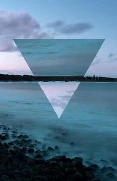 an image of a triangle in the water with sky and clouds behind it that is reflected in the water