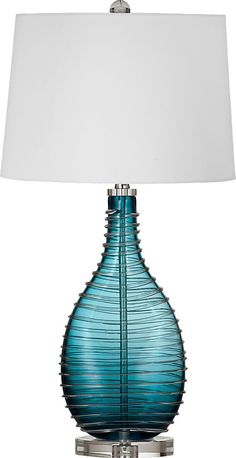 a blue glass table lamp with a white shade