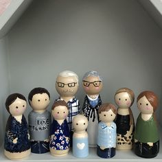 a group of wooden dolls sitting on top of a shelf