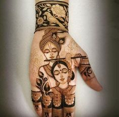 the hand is decorated with henna designs and an image of hindu deities on it