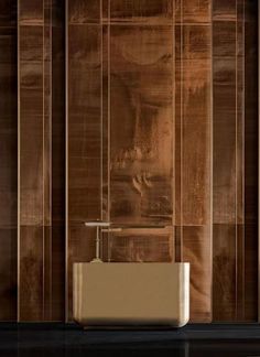 a bathroom sink sitting under a mirror next to a wooden wall with vertical stripes on it