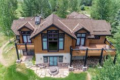 an aerial view of a home in the woods with lots of windows and wood sidings