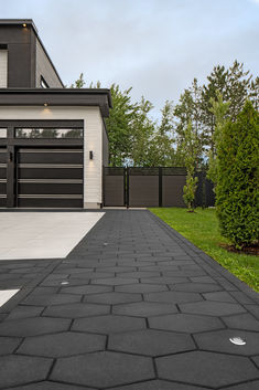 a house with a driveway leading to the front door and two garage doors on each side