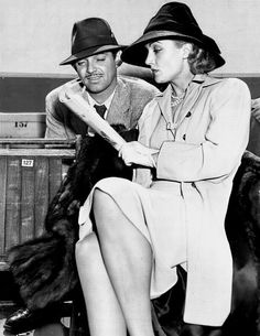 an old black and white photo of a man and woman sitting next to each other