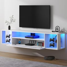 an entertainment center with a flat screen tv mounted on it's side and blue lighting